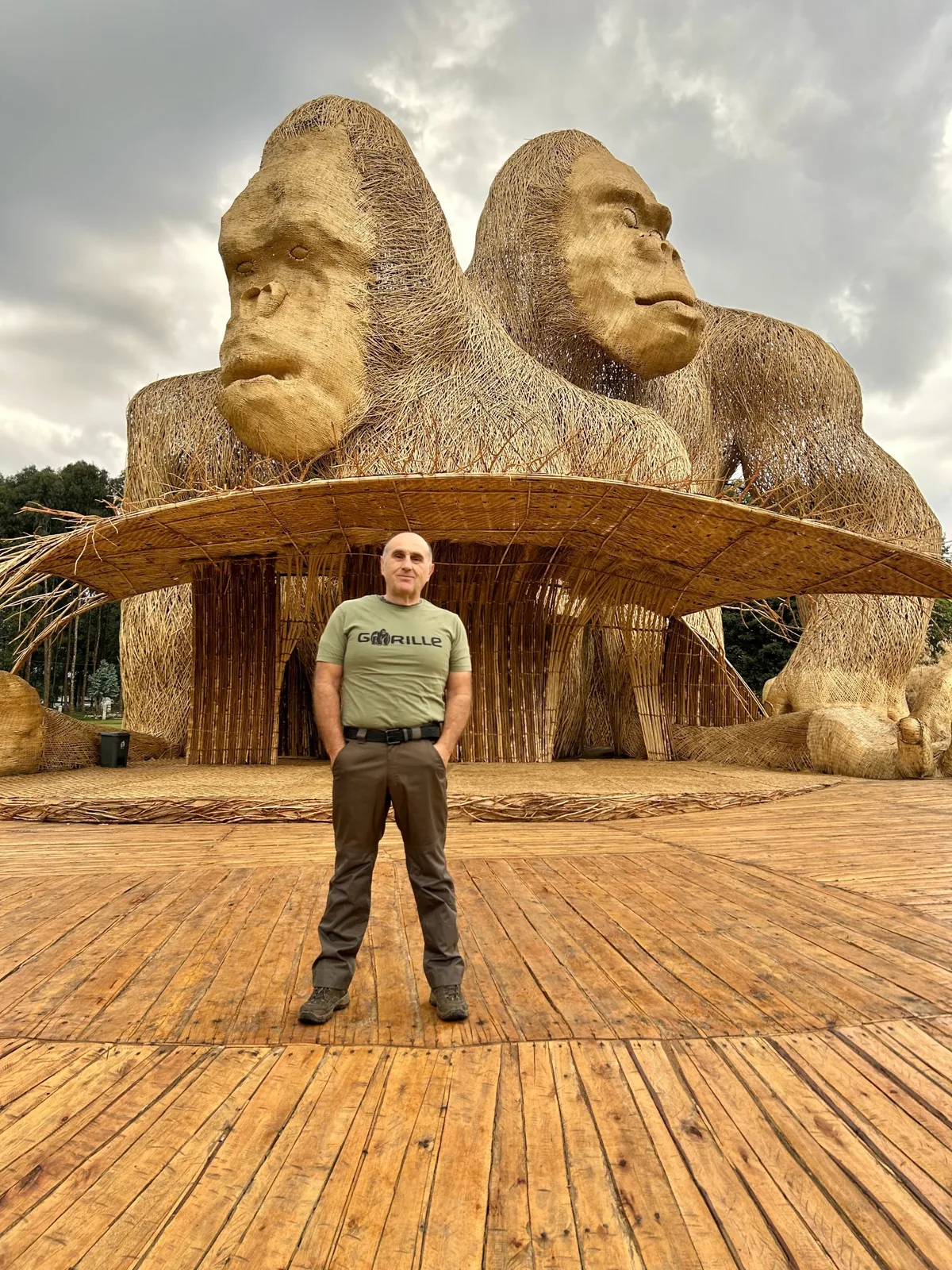Fabrice Martinez debout devant deux immenses gorilles en vannerie, sur le site de la Kwita Izina